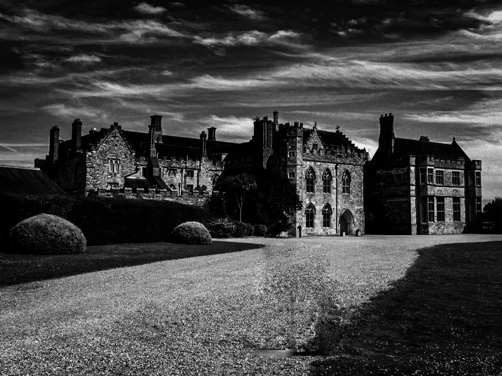 The abbey buildings of Battle Abbey School under a dark sky