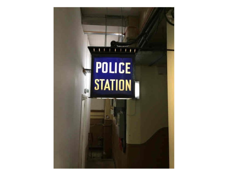 A blue police station lamp inside the old Brighton cells